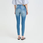 Model i lyseblå skinny jeans set bagfra med baglommer og flossede kanter ved anklen