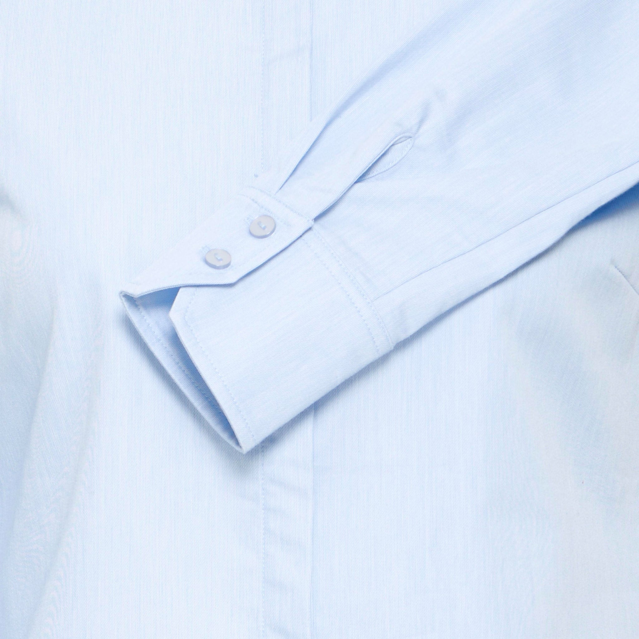 Detalje af blå skjorte i farven Vista Blue med manchet med to knapper, slids og skjult knapstolpe