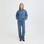 Model i blå wide leg jeans fra Pulz set forfra, stylet med denimskjorte og brune støvler