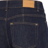 Nærbillede af baglomme med nitter og PULZ JEANS-mærke på mørkeblå jeans