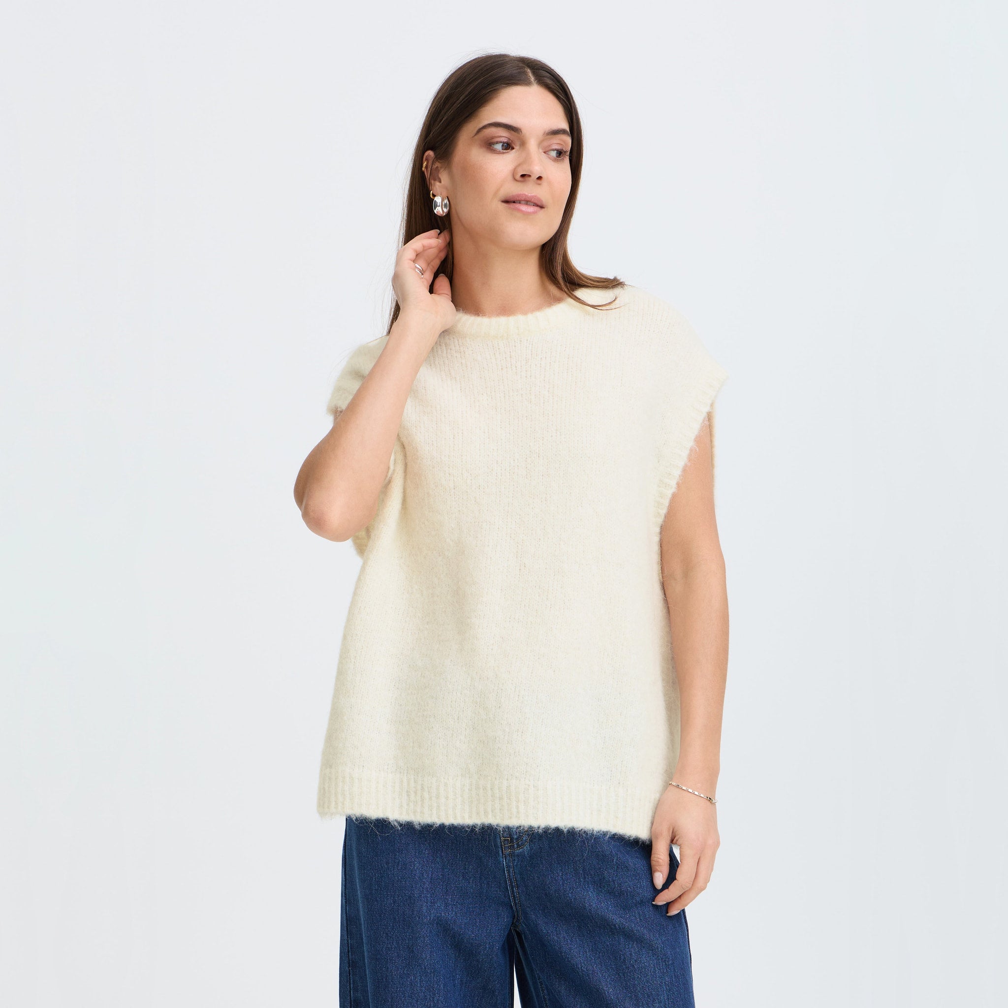Model i beige vest Georgie Slipover fra Pulz stylet med blå jeans, set forfra