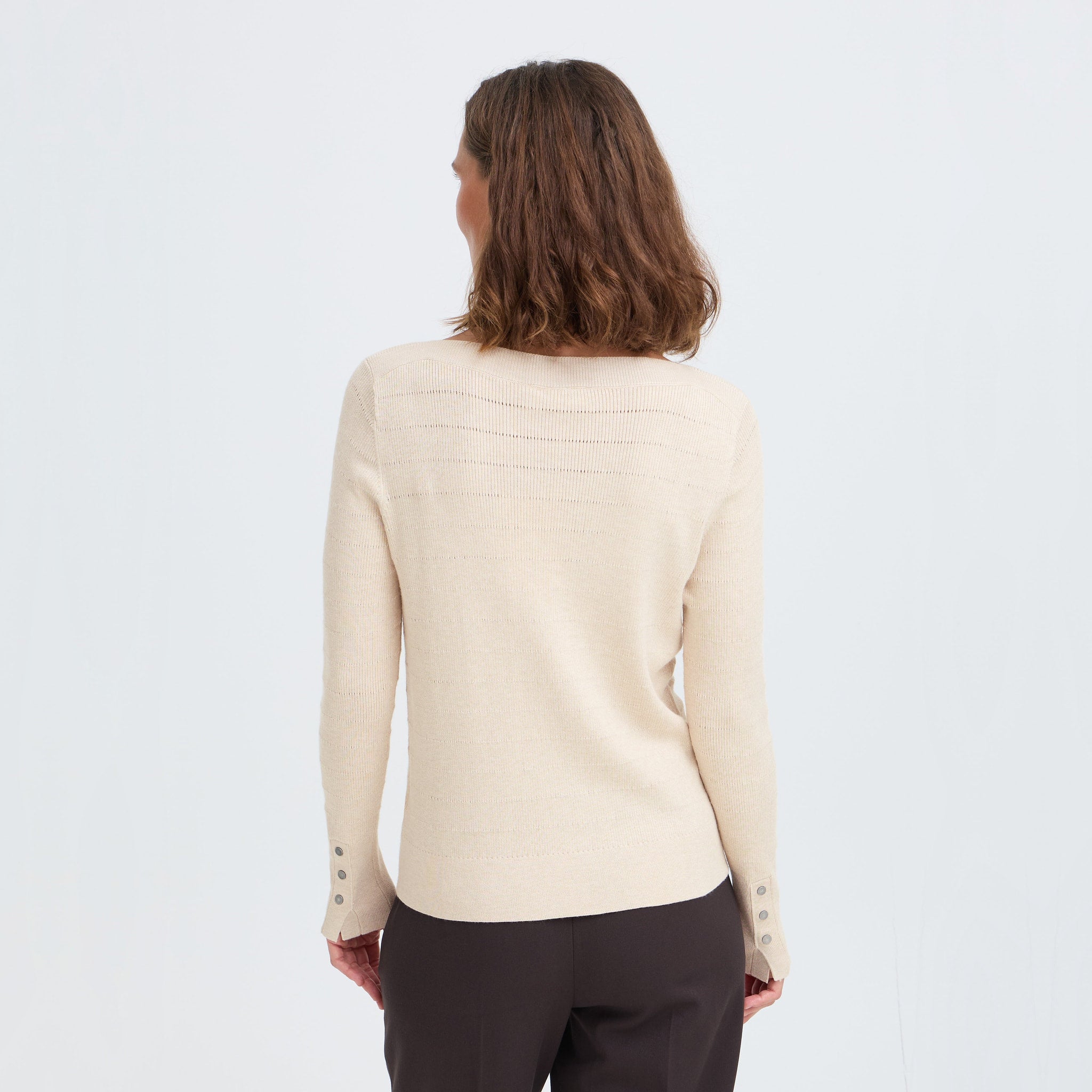 Model i beige Sara pullover fra Pulz set bagfra med knapdetalje ved ærmekanterne