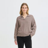 Model i brun pullover med polokrave og lange ærmer stylet med sorte bukser