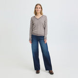 Model i brun stribet pullover med V-hals stylet med vide blå jeans og brune støvler