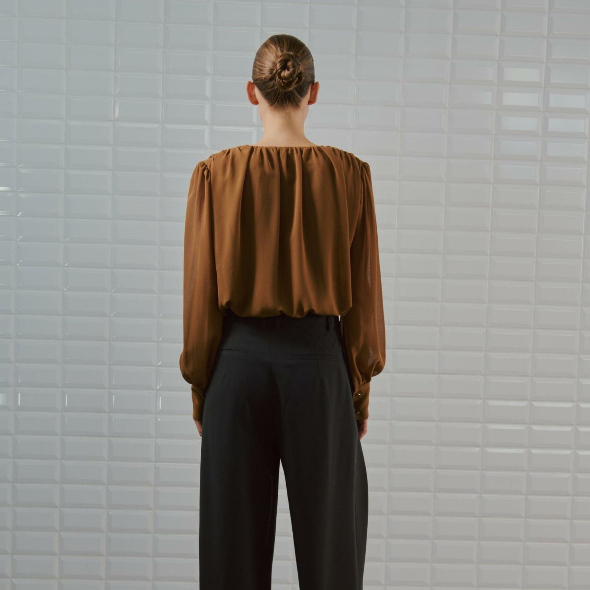 Brun bodystocking på model set bagfra med rynket ryg og lange ærmer