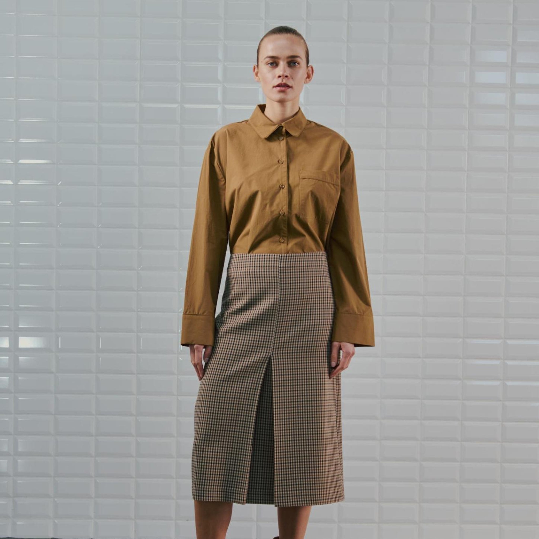 Model i ternet midi nederdel i brun og beige set forfra med slids foran