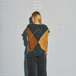 Model i langhåret harlekin vest i beige, brun og grå fra WithBlack, set bagfra