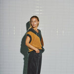Model i WithBlack harlekin vest set fra siden med det beige felt og sænkede skuldre