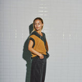 Model i WithBlack harlekin vest set fra siden med det beige felt og sænkede skuldre