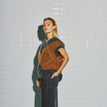 Model i harlekin vest fra WithBlack set skråt fra siden med det brune felt og ribkant