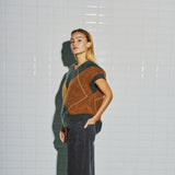 Model i harlekin vest fra WithBlack set skråt fra siden med det brune felt og ribkant