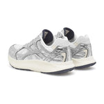 Par sølvfarvede Woden sneakers set skråt bagfra med marineblå for ved hælen