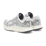 Par sølvfarvede Woden sneakers set skråt bagfra med marineblå for ved hælen
