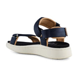 Navy sandal fra Woden set skråt bagfra med hælrem, lysebrune kanter og sort fodseng