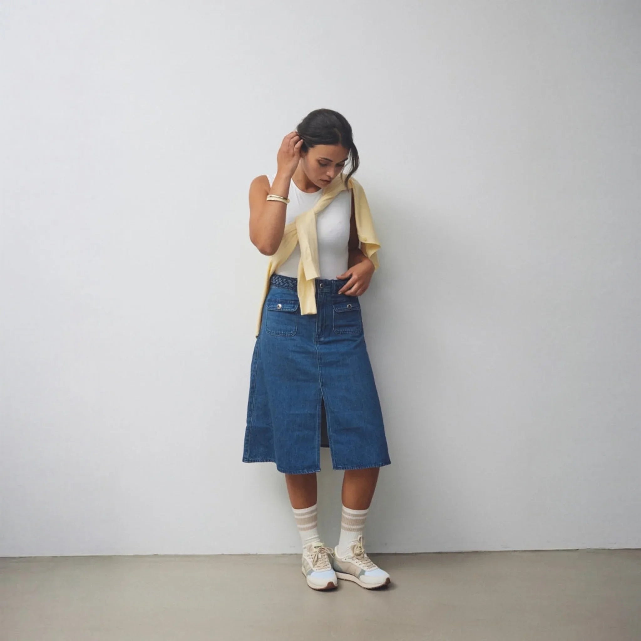 Model står i Woden Ronja sneakers stylet med nederdel i denim og hvide sokker