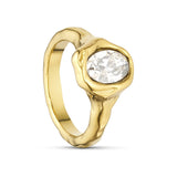 Guldfarvet ring fra Wolff Jewelry med klar oval sten og ujævn, organisk overflade set skråt fra siden