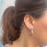 Sølvfarvet Emmi Hoops ørering på 30 mm båret i øret på model med hestehale, set fra siden