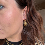 Model bærer Fanny Hoops øreringe i guld fra Wolff Jewelry, nærbillede af øret