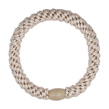 Beige flettet hårelastik fra Wolff Jewelry med beige plastikperle som lukning, set ovenfra