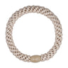 Beige flettet hårelastik fra Wolff Jewelry med beige plastikperle som lukning, set ovenfra