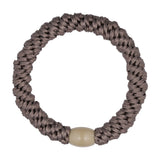 Beige hårelastik fra Wolff Jewelry i farven Taupe, flettet med lys beige perle i plastik, set ovenfra