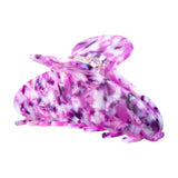 Lilla hårklemme i acetat med marmoreret mønster i lilla, pink og hvid, set fra siden med blank overflade