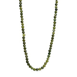 Grøn halskæde Jalle Pearl Necklace i Army med runde naturperler i grønne nuancer på lys baggrund
