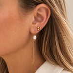 Mini Boble ørering i guld båret i øret sammen med en lang kædeørering med perle