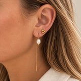 Mini Boble ørering i guld båret i øret sammen med en lang kædeørering med perle