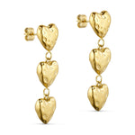 Rustic Heart ørering i guld fra Wolff Jewelry med tre hængende hjerter, set skråt fra siden på lys baggrund