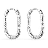 Sølvfarvede aflange øreringe med struktureret overflade fra Wolff Jewelry, set forfra på lys baggrund