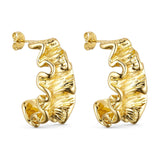 Rusty Hoops øreringe i guld fra Wolff Jewelry med bølget kant og rillet overflade set fra siden på lys baggrund