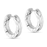 Små sølvfarvede øreringe fra Wolff Jewelry, kraftige hoops med hamret overflade set skråt forfra på lys baggrund