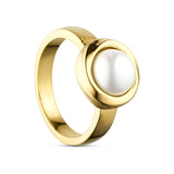 Sally ring i guld fra Wolff Jewelry med hvid perlelignende sten i rund indfatning, set skråt fra siden