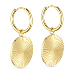 Sunny Hoops øreringe i guld fra Wolff Jewelry med rundt riflet vedhæng, set fra siden på lys baggrund