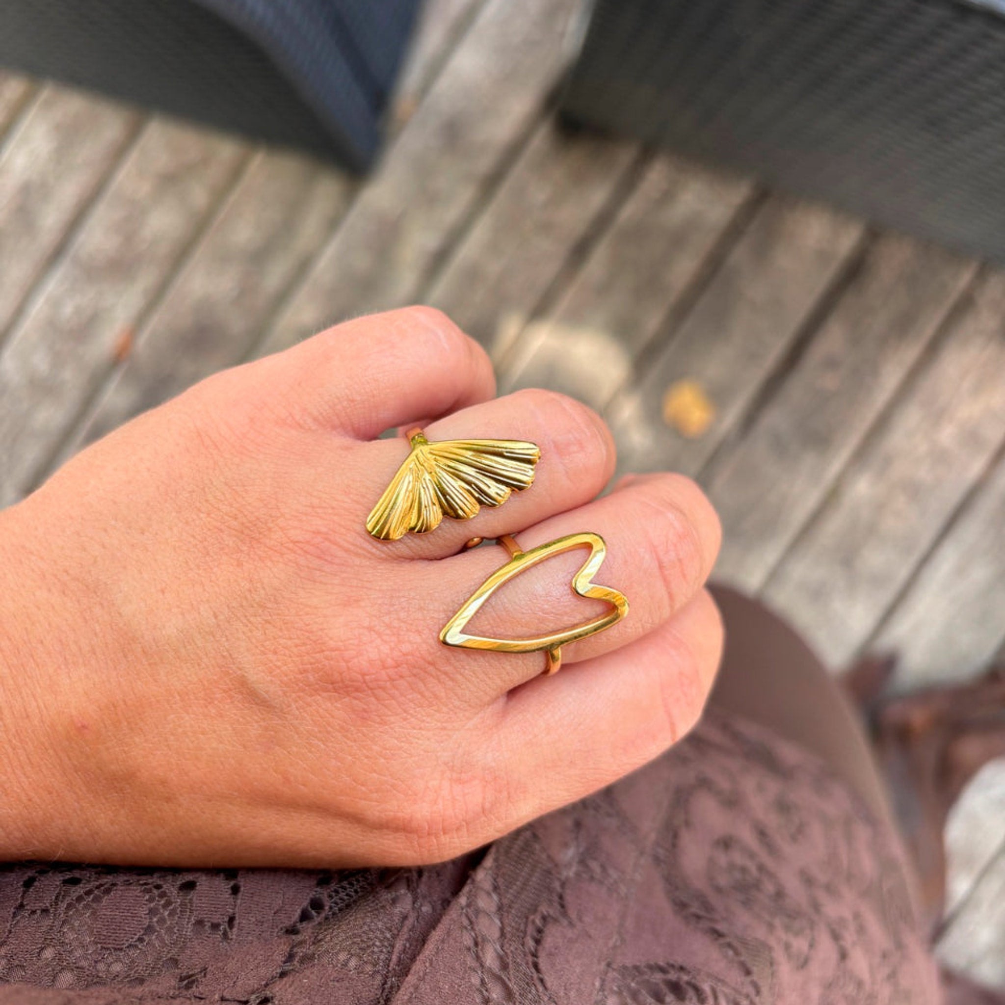 Guldfarvet Tempy ring med vifteformet motiv båret på fingeren sammen med en anden guldring