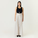 Model i hvide wide leg bukser med bælte, stylet med sort tanktop og flade sko
