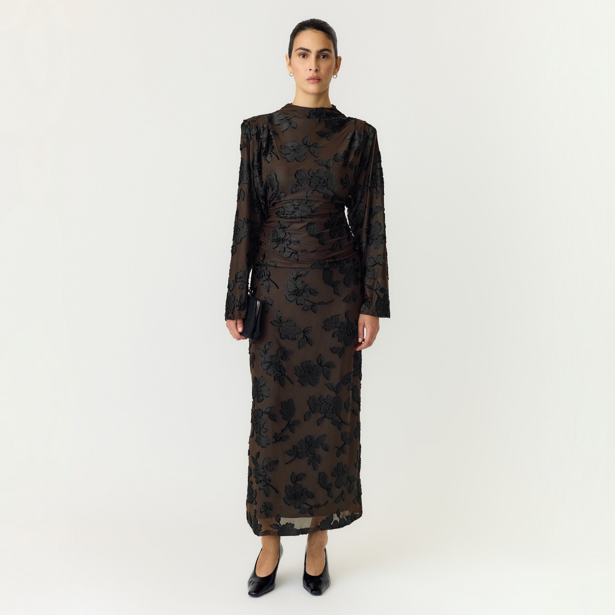 Model i brun top med sorte blomster stylet med matchende nederdel, sort taske og sorte sko