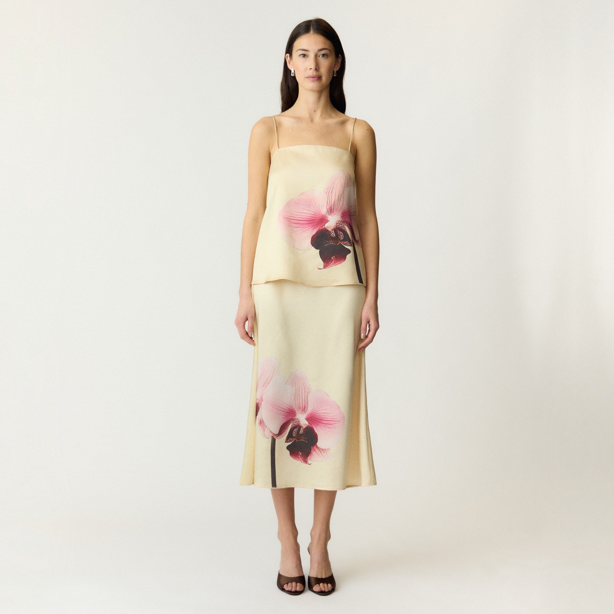 Model i hvid satin top med orkidéprint set forfra i hel figur