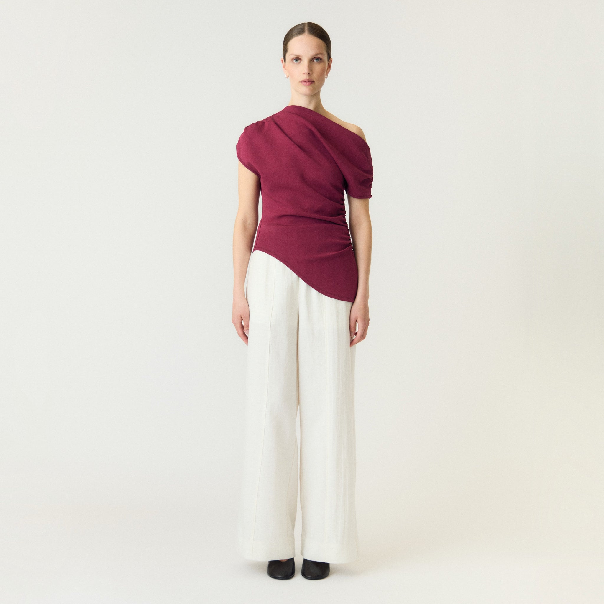 Model i pink off shoulder top fra YAS med bar skulder, stylet med hvide bukser med vide ben