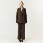 Model i brune wide leg bukser fra YAS stylet med en brun blazer, set forfra i fuld længde