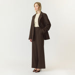 Model i brune wide leg bukser fra YAS med lys top og brun blazer, set fra siden