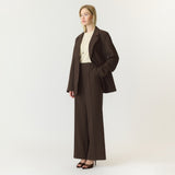 Model i brune wide leg bukser fra YAS med lys top og brun blazer, set fra siden
